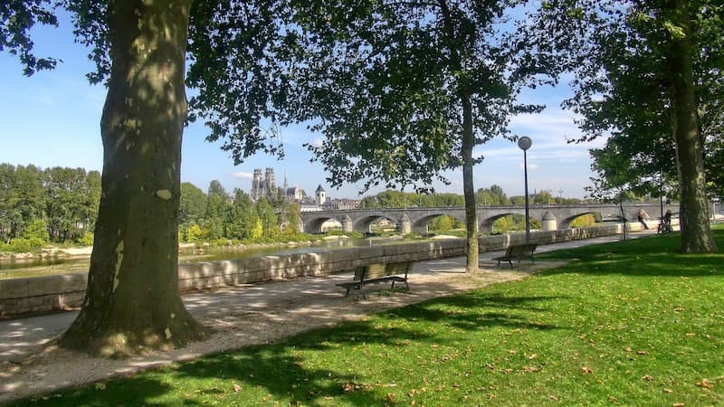 Cathédrale Sainte-Croix d'Orléans vue depuis les quais de Loire ombragés, avec le pont Royal au premier plan