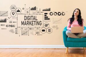 Femme avec ordinateur portable assise dans un fauteuil, concept de digital marketing avec graphiques muraux.